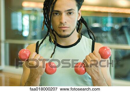 Young man working out with dumbbells View Large Photo Image Stock Photo - Young man working out with dumbbells. Fotosearch