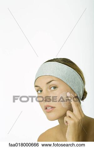 Young woman applying facial cleanser to cheek, head and shoulders View Large Photo Image Stock Photograph - Young woman applying facial cleanser to cheek, head and shoulders. Fotosearch