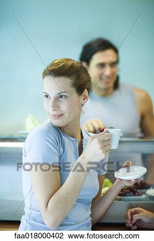 Young woman drinking coffee at snack bar, looking away View Large Photo Image Stock Image - Young woman drinking coffee at snack bar, looking away. Fotosearch
