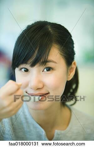 Young woman eating with soup spoon View Large Photo Image Stock Image - Young woman eating with soup spoon. Fotosearch