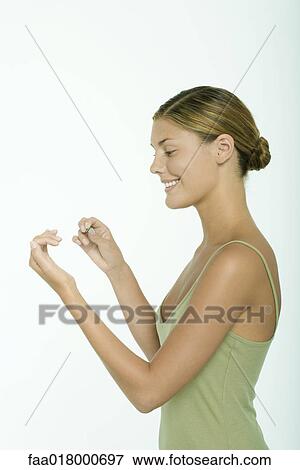 Stock Photo - Young woman filing fingernails. Fotosearch