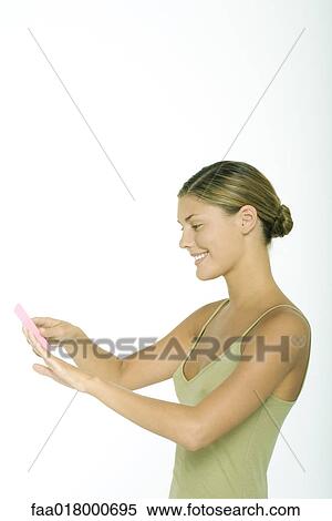Young woman filing fingernails View Large Photo Image Stock Photography - Young woman filing fingernails. Fotosearch