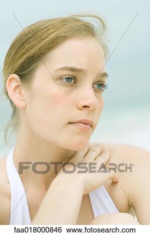 Stock Photograph - Young woman, head and shoulders, portrait, sea in background. Fotosearch