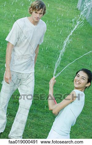Young woman holding up garden hose View Large Photo Image Stock Image - Young woman holding up garden hose. Fotosearch