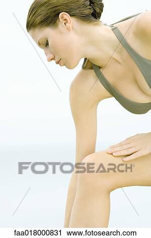 Stock Image - Young woman in bathing suit, leaning forward, cropped view. Fotosearch