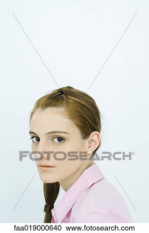 Stock Image - Young woman, looking at camera, portrait. Fotosearch