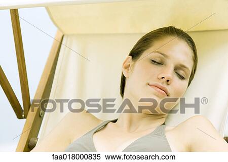Young woman lounging in beach chair, eyes closed View Large Photo Image Stock Photography - Young woman lounging in beach chair, eyes closed. Fotosearch