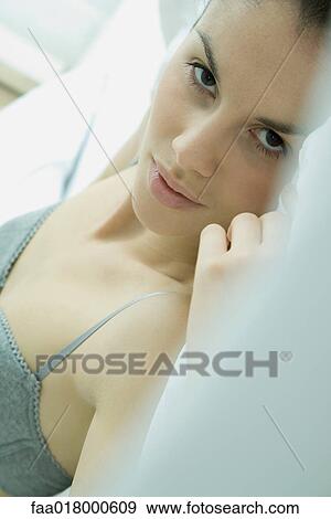 Young woman lying in bed, looking at camera View Large Photo Image Stock Photo - Young woman lying in bed, looking at camera. Fotosearch