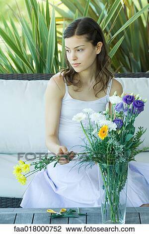 Stock Image - Young woman making fresh flower arrangement. Fotosearch