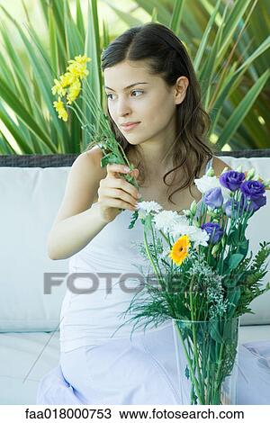Stock Image - Young woman making fresh flower arrangement. Fotosearch