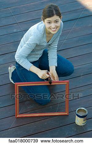 Young woman painting picture frame View Large Photo Image Stock Photo - Young woman painting picture frame. Fotosearch