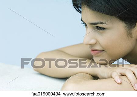Young woman resting heads on arms, smiling View Large Photo Image Picture - Young woman resting heads on arms, smiling. Fotosearch