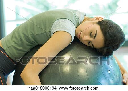 Young woman resting on fitness ball View Large Photo Image Picture - Young woman resting on fitness ball. Fotosearch