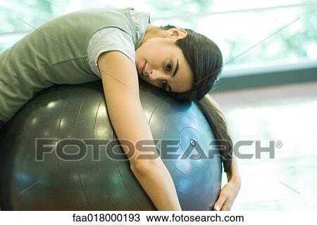 Young woman resting on fitness ball View Large Photo Image Stock Image - Young woman resting on fitness ball. Fotosearch
