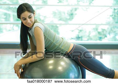 Young woman resting on fitness ball View Large Photo Image Stock Photo - Young woman resting on fitness ball. Fotosearch