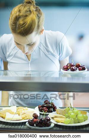 Young woman standing, choosing healthy snack in cafeteria View Large Photo Image Stock Image - Young woman standing, choosing healthy snack in cafeteria. Fotosearch