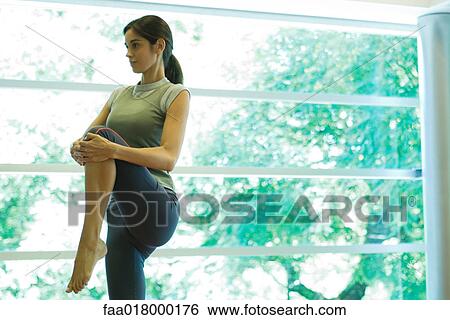 Young woman stretching knee View Large Photo Image Stock Photograph - Young woman stretching knee. Fotosearch