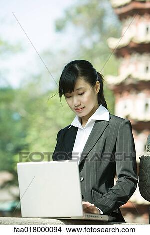 Picture - Young woman using laptop. Fotosearch
