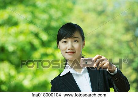 Young woman using photophone, smiling at camera View Large Photo Image Picture - Young woman using photophone, smiling at camera. Fotosearch