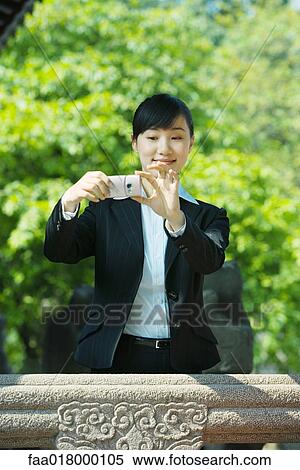 Stock Photography - Young woman using photophone. Fotosearch
