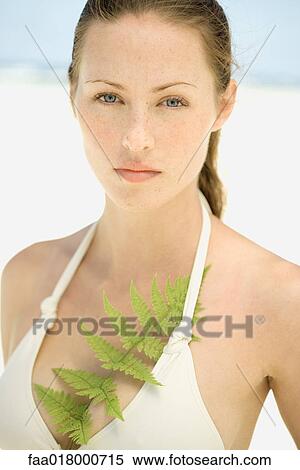 Stock Photography - Young woman wearing bathing suit, fern leaf in top. Fotosearch