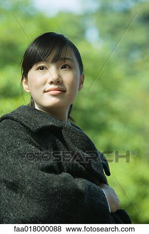 Stock Photo - Young woman wearing coat, portrait. Fotosearch