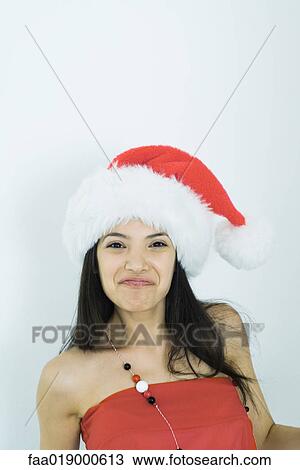 Young woman wearing santa hat, portrait View Large Photo Image Stock Image - Young woman wearing santa hat, portrait. Fotosearch