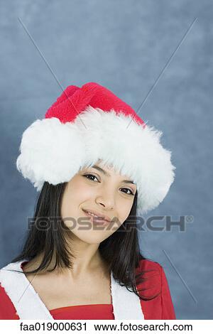 Young woman wearing santa hat, portrait View Large Photo Image Stock Image - Young woman wearing santa hat, portrait. Fotosearch