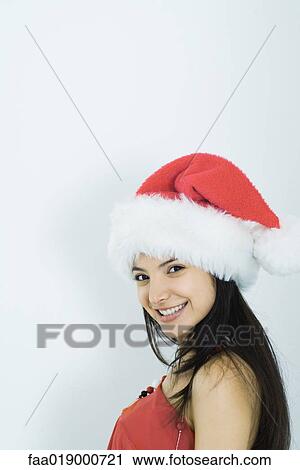 Young woman wearing santa hat, portrait View Large Photo Image Stock Image - Young woman wearing santa hat, portrait. Fotosearch
