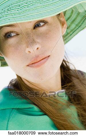 Stock Photo - Young woman wearing sun hat, close-up . Fotosearch