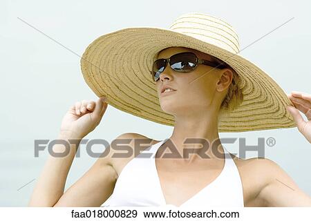 Young woman wearing sunhat and sunglasses View Large Photo Image Stock Photo - Young woman wearing sunhat and sunglasses. Fotosearch