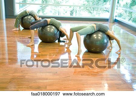 Stock Photo - Young women doing backbends on fitness balls. Fotosearch