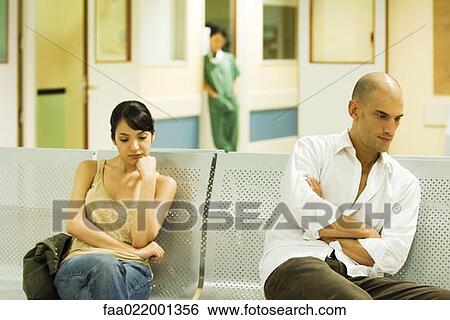 Adults sitting in hospital waiting room, looking away View Large Photo Image Stock Photograph - Adults sitting in hospital waiting room, looking away. Fotosearch