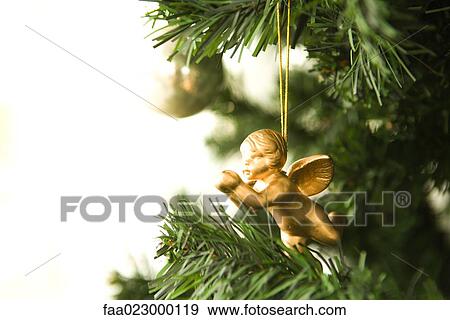 Angel Christmas ornament hanging from Christmas tree, cropped view View Large Photo Image Stock Photo - Angel Christmas ornament hanging from Christmas tree, cropped view. Fotosearch