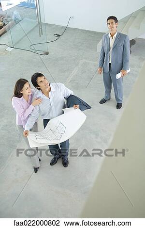 Architect showing unfinished house to enthusiastic young couple, high angle view View Large Photo Image Stock Image - Architect showing unfinished house to enthusiastic young couple, high angle view. Fotosearch