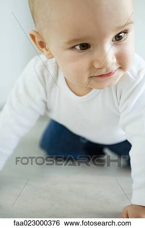 Baby crawling on floor, looking away, smiling, close-up View Large Photo Image Stock Photograph - Baby crawling on floor, looking away, smiling, close-up. Fotosearch