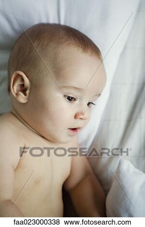 Baby in bed, looking down, close-up View Large Photo Image Stock Photo - Baby in bed, looking down, close-up. Fotosearch