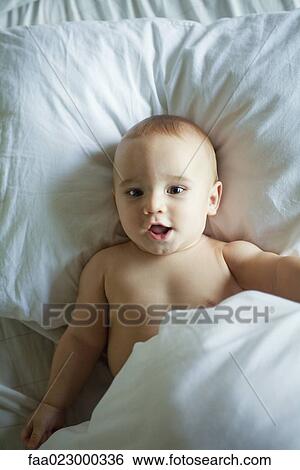 Baby in bed, waist up View Large Photo Image Stock Photograph - Baby in bed, waist up. Fotosearch