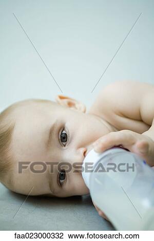 Baby lying down, drinking from bottle View Large Photo Image Stock Image - Baby lying down, drinking from bottle. Fotosearch