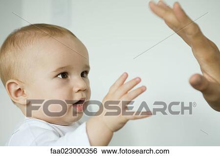 Stock Photograph - Baby reaching for mother's hand. Fotosearch