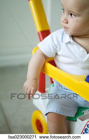 Baby sitting in toy stroller, looking away View Large Photo Image Stock Image - Baby sitting in toy stroller, looking away. Fotosearch
