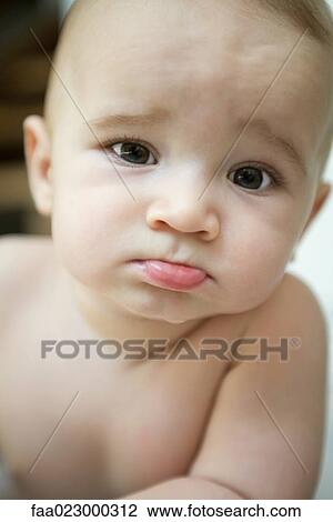 Baby sticking out lower lip and furrowing brow, looking at camera, close-up View Large Photo Image Stock Image - Baby sticking out lower lip and furrowing brow, looking at camera, close-up. Fotosearch