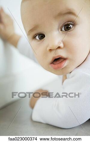 Baby turning head to look at camera, close-up View Large Photo Image Picture - Baby turning head to look at camera, close-up. Fotosearch