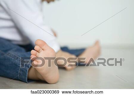Baby wearing jeans, sitting on floor, low section, focus on foreground View Large Photo Image Stock Photo - Baby wearing jeans, sitting on floor, low section, focus on foreground. Fotosearch