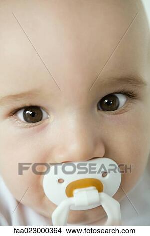Baby with pacifier in mouth, close-up View Large Photo Image Picture - Baby with pacifier in mouth, close-up. Fotosearch