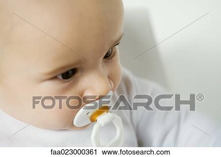 Baby with pacifier in mouth, close-up View Large Photo Image Stock Image - Baby with pacifier in mouth, close-up. Fotosearch