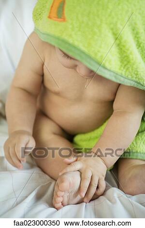 Stock Image - Baby wrapped in towel after bath, drooling. Fotosearch