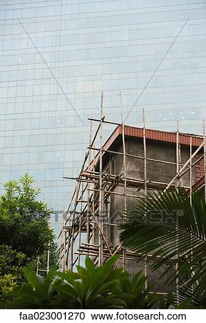Bamboo scaffolding around building, glass facade of skyscraper in background View Large Photo Image Stock Image - Bamboo scaffolding around building, glass facade of skyscraper in background. Fotosearch