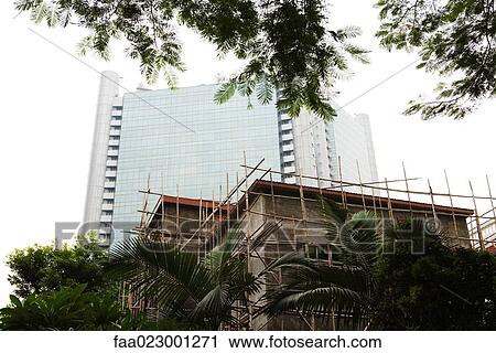 Bamboo scaffolding around building, modern high rise in background View Large Photo Image Stock Image - Bamboo scaffolding around building, modern high rise in background. Fotosearch
