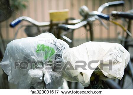Bicycle seats covered with plastic bags, close-up View Large Photo Image Stock Photo - Bicycle seats covered with plastic bags, close-up. Fotosearch